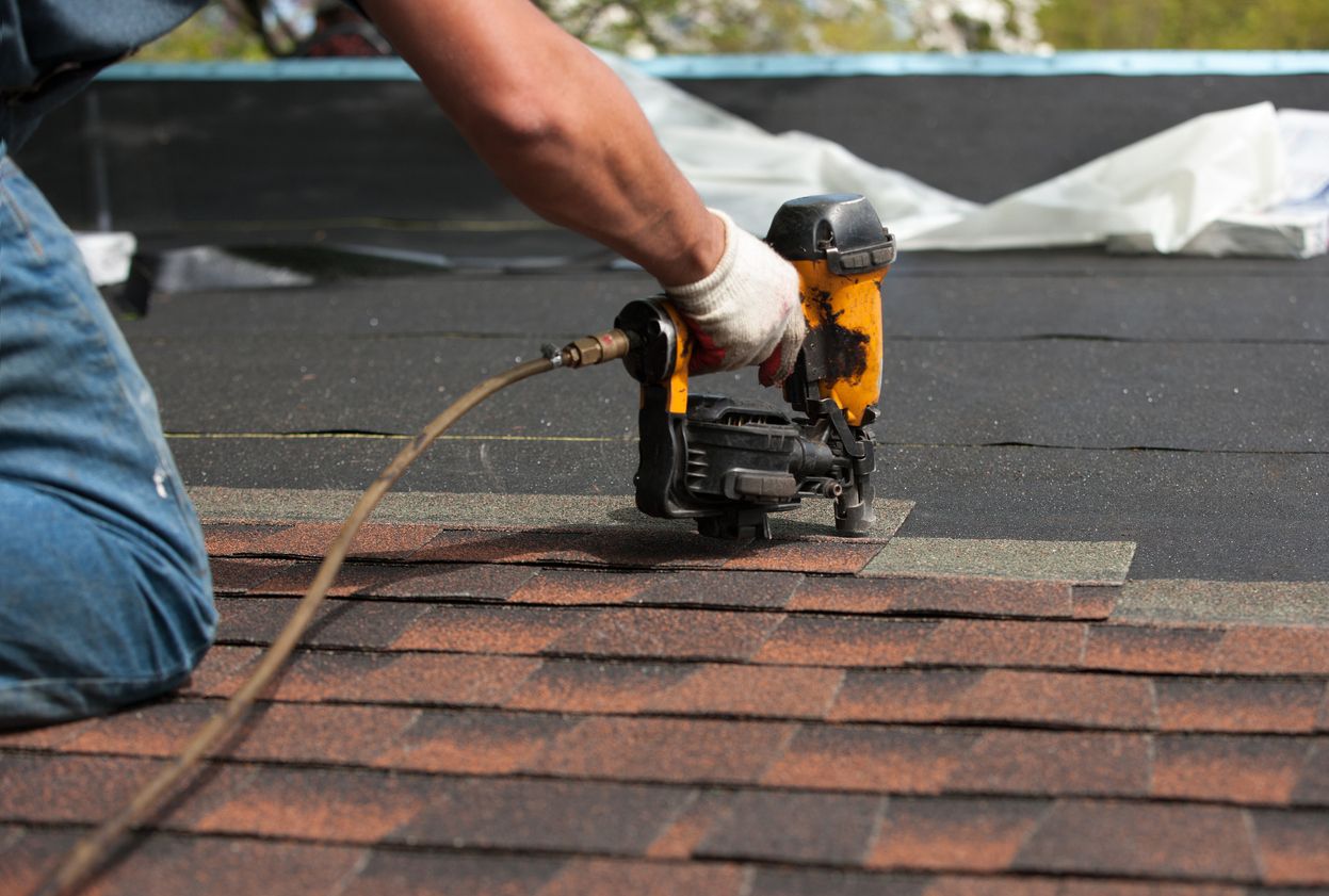 Roofer nailing architectural shingles on a Metro East home